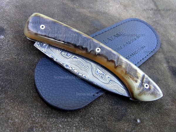 Couteau pliant L.LATASTE manche en croute de corne de bélier et lame damas avec son étui de protection (fourreau de poche).