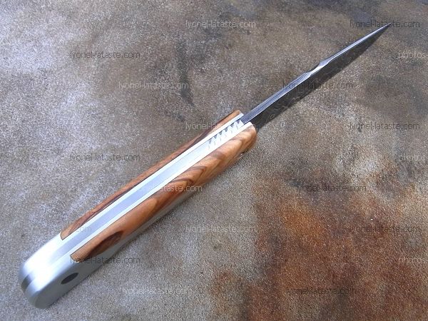 Couteau LE BACASSIER manche en olivier avec petit guillochage sur le ressort ainsi que le dos de lame.