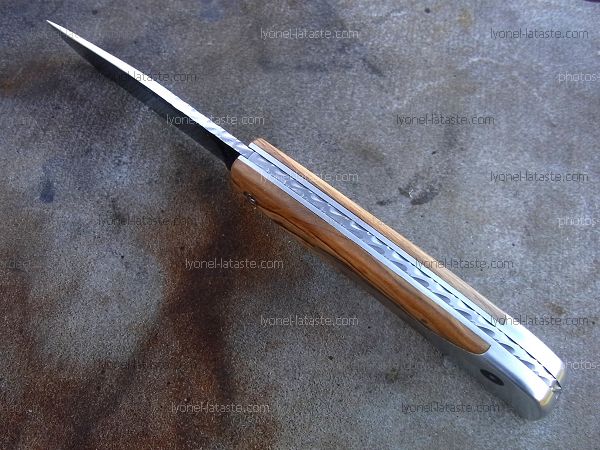 Couteau LE BACASSIER manche en olivier avec guillochage complet du ressort ainsi que du dos de la lame.