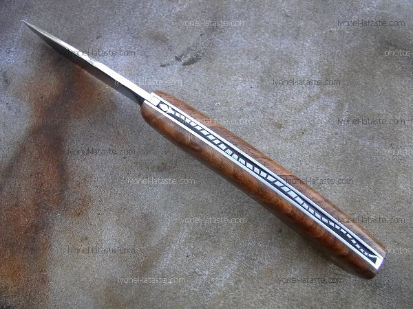 Couteau pliant Le GRAAL avec guillochage sur le dos du ressort et à l'intérieur. Guillochage du dos de la  lame.