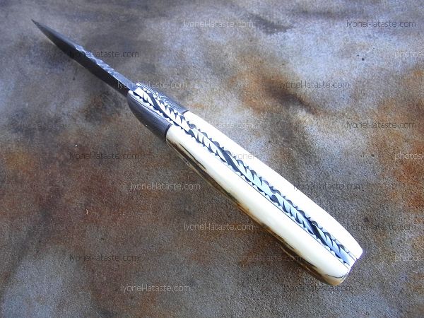 Couteau Le GRAAL ivoire de mammouth fossilisé avec guillochage sur le dos du ressort et à l'intérieur. Guillochage dos de lame et sur tout le tour intérieur des platines.