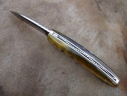 Couteau pliant L.LATASTE manche en très vieux châtaignier et lame en acier xc75 brut de forge avec une volute forgée.