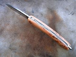 Couteau pliant L.LATASTE avec guillochage sur le dos du ressort serpent et classique à l'intérieur, volute forgée. Guillochage du dos de la lame