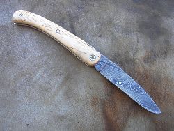 Couteau LOU PALOUMAYRE avec manche en bouleau madré et lame en damas forgé.