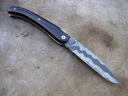Couteau LOU PALOUMAYRE avec manche en ébène et lame en damas forgé.