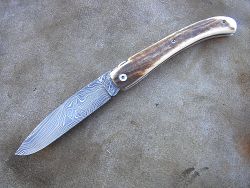 Couteau LOU PALOUMAYRE avec manche en bois de cerf et lame en damas forgé.