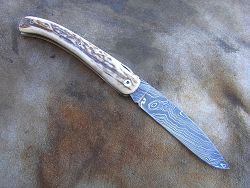 Couteau LOU PALOUMAYRE avec manche en bois de cerf et lame en damas forgé.