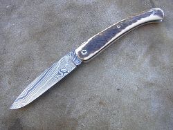Couteau LOU PALOUMAYRE avec manche en bois de cerf et lame en damas forgé.