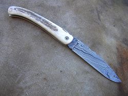 Couteau LOU PALOUMAYRE avec manche en bois de cerf et lame en damas forgé.