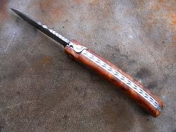 Couteau LOU PALOUMAYRE manche en racine de thuya, guillochage total du  ressort, dos de la lame et vis de serrage.