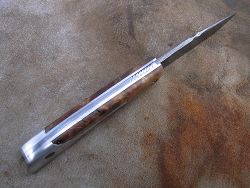 Couteau LE BACASSIER manche en loupe de peuplier stabilisée avec petit guillochage sur le ressort ainsi que le dos de lame.