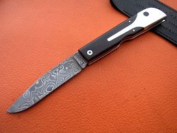 Couteau LE BECASSIER manche en ébène et lame en damas forgé.