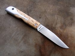 Couteau LE BACASSIER manche en bouleau avec guillochage complet du ressort ainsi que du dos de la lame.