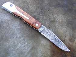 Couteau LE BECASSIER manche en hêtre teinté (châtaigne) et stabilisé et lame en damas forgé.