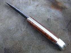 Couteau LE BACASSIER manche en racine de thuya avec petit guillochage sur le ressort ainsi que le dos de lame.