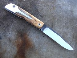 Couteau LE BECASSIER manche en racine de thuya, présentation dessus du couteau.