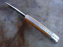 Couteau LE BACASSIER manche en ébène avec guillochage complet du ressort ainsi que du dos de la lame.