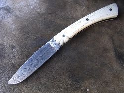 Couteau Le GRAAL manche en hêtre échauffé et lame en damas forgé.