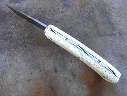 Couteau Le GRAAL lame damas avec guillochage sur le dos du ressort et à l'intérieur. Guillochage dos de lame.