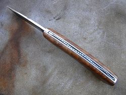 Couteau pliant Le GRAAL avec guillochage sur le dos du ressort et à l'intérieur. Guillochage du dos de la  lame.