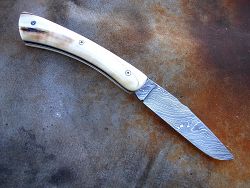 Couteau Le GRAAL manche en ivoire de phacochère avec lame en damas forgé motif torsadé