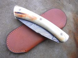 Couteau Le GRAAL ivoire de phacochère, lame damas, livré avec son étui de protection en cuir. (fourreau de poche)
