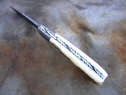 Couteau Le GRAAL ivoire de mammouth fossilisé avec guillochage sur le dos du ressort et à l'intérieur. Guillochage dos de lame et sur tout le tour intérieur des platines.