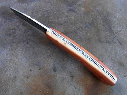 Couteau Le GRAAL manche en genévrier avec guillochage sur le dos du ressort et à l'intérieur. Guillochage dos de lame.