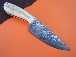 Dague de chasse avec manche en oryx avec garde et lame damas forgé.