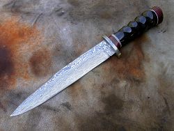 Dague de chasse avec manche en oryx avec garde et lame damas forgé.