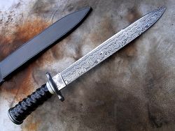 Dague de chasse avec manche en bois de cerf et lame en damas forgé.