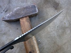 Couteau forgé manche olivier, lame en acier avec guillochage.