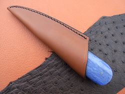 Couteau à huitre os teinté et lame damas dans son étui en cuir.